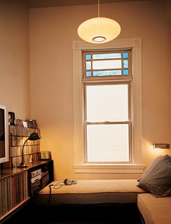 Bay Wash - Photo 5 of 9 - The media room, which formerly housed domestic help, is illuminated by a George Nelson Saucer lamp. Azevedo designed and built the cabinetry and the daybed and couch.