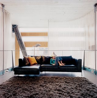 The hanging living room gains greater privacy via a gauzy curtain wall.