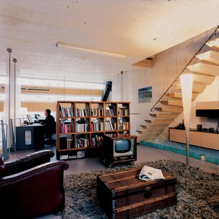 Weijnen's office adjoins the living room, an open area furnished with a 1950s television cabinet (housing a new TV), a battered armchair found on the street, a Fellice Rosso leather sofa, and a Koot Licht floor lamp.