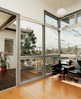 The second-floor deck looks out onto the green canopy of Garcetti and Wakeland's neighborhood and indoors to a pair of Vatne Møbler rosewood lounge chairs.