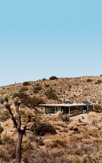 The "iT House" near Joshua Tree National Park features solar panels to catch the sun's energy, wide expanses of open doors and windows to provide cross-ventilation, and strategic overhangs offering shade against the desert's endless heat.