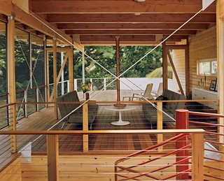 The living room, which opens directly to an ipe deck, is separated from the dining area by a central spiral staircase.