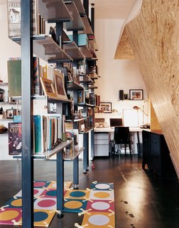 Custom-fabricated modular bookshelves create a corridor leading to the home office.