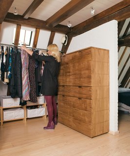 Few structural additions were made to the apartment, but the half wall in the top-floor bedroom was one of them The wall and an elegant chest of drawers by Peter Laszlo create storage for clothes without breaking up space. The white-painted brick of the new wall blend in with the original 17th-century walls.