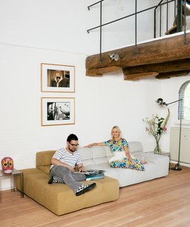 The floor is new and the brickwork has been whitewashed to create a cleaner feel, but the beams supporting the gallery were left in their original state, as were the paint-splattered iron railings. The Tufty Time sofa is by Patricia Urquiola for B&B Italia, and the acrylic tables are from Kartell. The prints are from Hindman's personal collection.