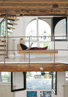 A George Nelson daybed takes center stage at gallery level. Part of the couple's collection of American mid-century design, it harmonizes with the newer Dutch pieces and with the apartment's 17th-century architecture.