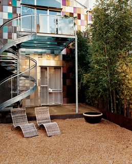 The rain garden is framed by bamboo on one side and horsetail on the other. A filter fabric beneath the pebbles helps direct water from the roof into the planters and the ground, eliminating runoff.