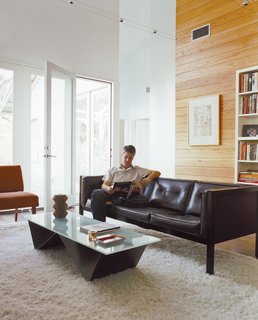The living room isn’t large, but its high ceiling makes it feel airy, and furniture on slender legs allows light and air to circulate through the space.