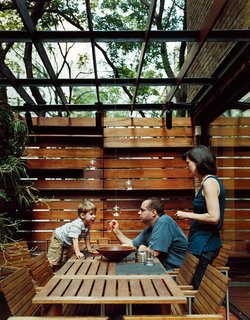 An outdoor dining area is screened for privacy.