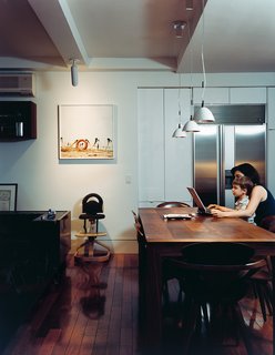 The kitchen has a dining table of black American walnut designed by Brad. The pendant lights are by Ingo Maurer.