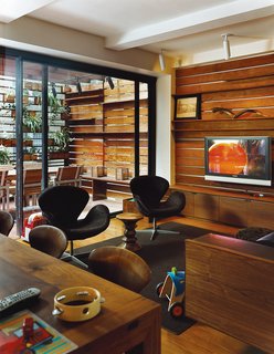 The Zizmors extended their living room by installing an 8-by-15-foot sliding glass door, which leads to an outdoor dining area built six feet above the alley. To make the outdoors feel like it's part of the living room, and not a separate patio, they ran the same horizontal pattern of ipe wood slats from the indoors out.