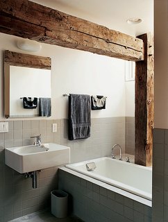 Raising the Barn - Photo 5 of 7 - Rather than concealing the barn frame in the private rooms, Cohen created an interplay between modern and historic elements in the master bathroom.