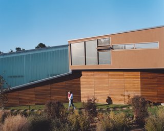 The Shermans’ home is designed to blend effortlessly with the hillside on which it rests by using a muted material palette of troweled plaster and cedar planking.