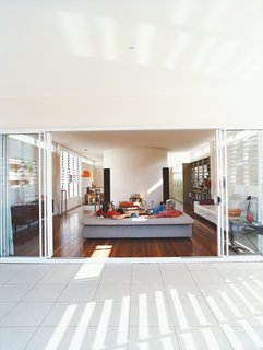 Minimalist Bachelor Pad in Brisbane - Photo 4 of 8 - Clayden and Sam Cutler, both former tour managers for rock bands, talk music in the spacious, uncluttered living room that opens onto the balcony.