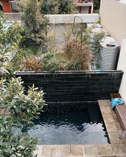 The lush backyard garden, with therapy pool in the foreground, hosts the green wall, which reduces the house’s drain on city water by 75 percent. Hidden behind the stone feature wall are three 800-gallon rainwater tanks that store whatever water falls from the skies.