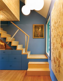The painting on the landing of the stairs leading to the guest room is a junk-store find. Santiago was especially struck by the incongruity of a New England artist employing such tropical, Gauguin-like colors.