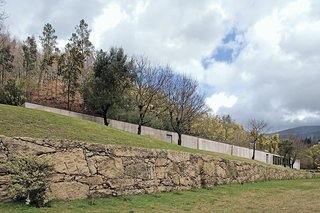 With its simple rectangular form, the house has an infrastructural presence in the landscape, making it appear as if the house itself is holding back the steep hill.