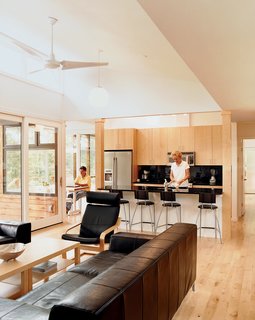 Part of the Plan - Photo 2 of 4 - The Kieslings in their open kitchen. The maple used throughout references the maple trees that surround the house.