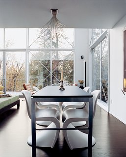 The house’s open spaces are minimally furnished with modern classics like Verner Panton chairs in the dining area.