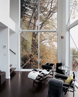 A Corbusier chaise and Eileen Gray end table fill out the corner of the couple's high-ceilinged living area, which helps create the desired loftlike feel of the home.