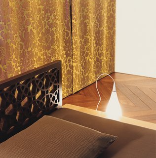 Palace Intrigue - Photo 8 of 13 - The bed, on the mezzanine, has a B.Lux "Nite" light at its side. The drapes, from Designers Guild, hide the wall closet.
