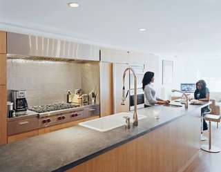 The kitchen has ample cooking space and room for a crowd. The Ann Sacks tile backsplash softens the line of the stainless steel, while the black absolute granite countertop adds a muted counterpoint. Kohler and Grohe fixtures ensure that dishes can be tackled double-team style.