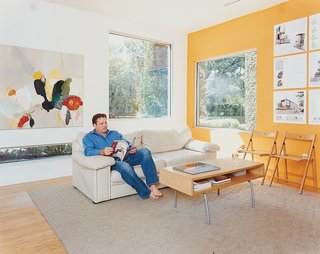 Baton Rouge Oasis - Photo 4 of 13 - Baird relaxes in the bright living room, which is decorated spartanly with the architect’s own artwork, a couch, and a coffee table by IKEA.
