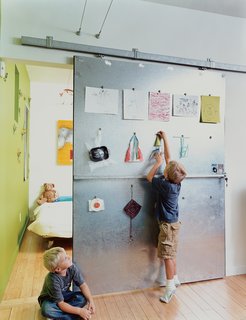 Baton Rouge Oasis - Photo 6 of 13 - David Baird designed the custom sliding doors with materials and hardware from Home Depot. The doors also act as a makeshift critique wall for Bo and Sky’s artwork.