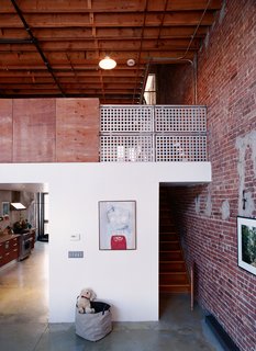 A House Grows in Brooklyn - Photo 4 of 5 - By leaving the exterior walls of the neighboring structures exposed on their interior, Miro and Weiss guaranteed that the neighborhood’s history would be a part of their new home. Raw plywood and industrial-strength steel railings are balanced with custom finishes and signs of domesticity.