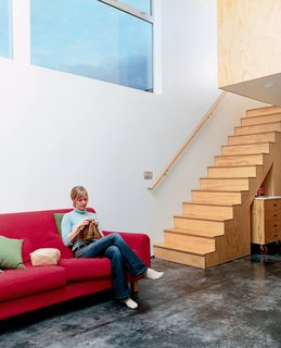 David’s wife, Jodi, knits it up on the IKEA couch. The floor color, Sarti explains, "comes from the natural efflorescence that occurred as the concrete cured."