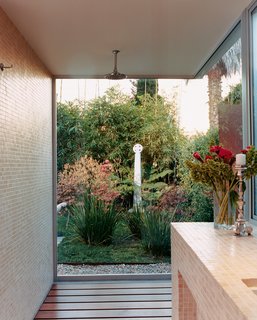 Only glass separates Farmer and Kozely from their backyard (and Celtic cross reproduction) when they shower. The shower floor is ipe wood; the walls are covered in one-inch-square travertine mosaics.