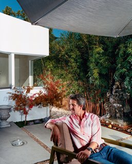 The front, middle, and rear yards are conceived as outdoor rooms. Pierre Kozely relaxes <br><br>in the middle yard in a prototype of an outdoor furniture line by Pietrarte. A bronze Ganesh is on a raised pedestal in the middle of a small water feature.