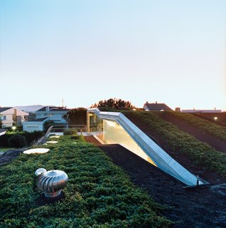 The hydroponic rooftop garden grows out of volcanic stones. The home is conceived as a giant C-shaped spiral.