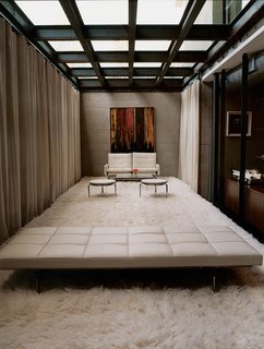 The Jonathan - Photo 7 of 10 - The industrial aesthetic of the Segals’ lounge area is softened by a white shag rug and the generous sunlight that streams through its ceiling of thick glass. The seating is by Paul Kjaerholm.