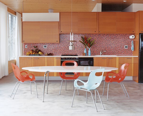 Go With the Flow - Photo 9 of 11 - The concrete floor takes on a silky appearance in the kitchen and dining areas. The Gideå table is from IKEA, the Karim Rashid Oh chairs are from Umbra, and the Erik Magnussen kerosene Ship’s lamp is by Stelton.