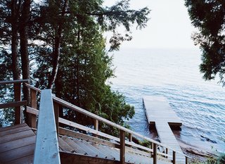 A wooden stair leads from the house down to a dramatic view of Lake Superior.