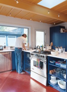 Primary colors and uncomplicated spaces define the interiors of both sheds. Golob is shown above in the modest open kitchen, where appliances were chosen for "cost, durability, and efficiency."