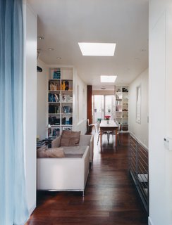 Once a split-level jumble of small, dark rooms, the main floor now offers a clear sight line from the patio straight through the kitchen, dining room, sitting area, and spare room to the street-facing window (with two skylights for added illumination).