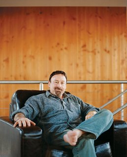 Scott Stafne relaxes in his upstairs office/TV room in his Natuzzi lounge chair.