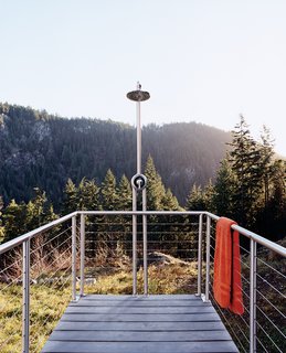 Mimicking the cantilever of the house, an outdoor shower just off the master bedroom stretches out gently toward the surrounding woods.
