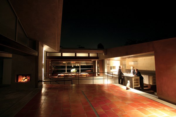 The two sides of the house look across the courtyard at each other, and are bridged by the dining room, which looks out onto the street below like the wheelhouse of a ship. “Everyone ends up in the kitchen anyway, so why not put the kitchen in the courtyard?” says Robertson. The kitchen features a NanaWall system that opens directly to the outdoors. The only two enclosed rooms in the house are the bedrooms. Photo 2 of Courtyard House modern home
