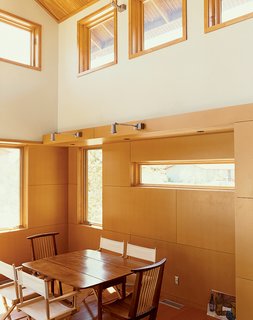 Light pours into the Ankneys’ living/dining area with its clear pine plywood ceiling, clear-finish MDF paneling on the walls, and reclaimed-fir flooring.