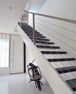 The home’s entryway features fly-ash concrete floors and stairs cut from recycled steel.