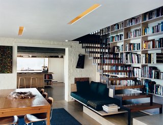 Inside, a suspended staircase rises up past the couple’s bookcase over a well-lit seating nook. Aalto stools by Artek join Eames molded plywood dining chairs by Herman Miller to give an especially modern touch to the kitchen.