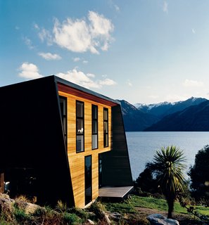 The sunny side of the home is clad in cedar weatherboards and features sleeping quarters on the upper level with living spaces below.
