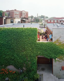 A wide cut across the top of the structure made room for a second-floor courtyard where the family can catch some sun but maintain their privacy. On the ground level, the front door is tucked into an ivy-covered alcove lined with ipe, a material used throughout the house.