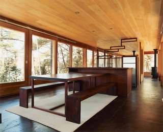 Eco-Friendly Rustic Cabin Retreat in Canada - Photo 1 of 4 - Barerock’s minimal interior is augmented by a built-in dining area made from African padauk, a decay-resistant hardwood. The mirrored kitchen wall echoes the exterior’s distinguishing feature.