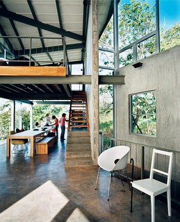 Exposed beams and a cantilevered loft soar over the high-traffic eating area, giving the family a sense of spaciousness.