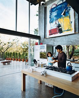 José Roberto, who says his family is always cooking something, prepares a snack with Jimena on the Ariston gas cooktop installed on the custom table.