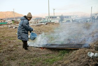 The craftsman pours water over the boards to halt the charring process.